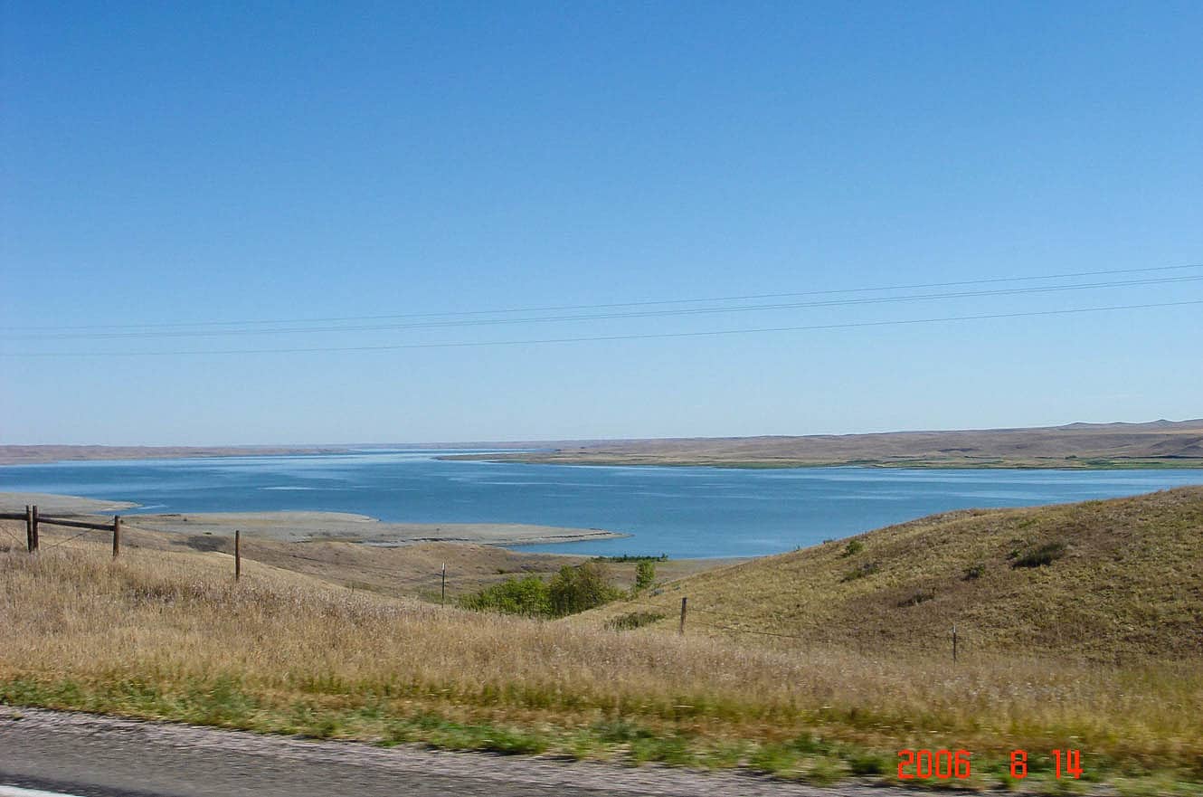 A calm blue lake with a grassy shoreline along the Missouri River route