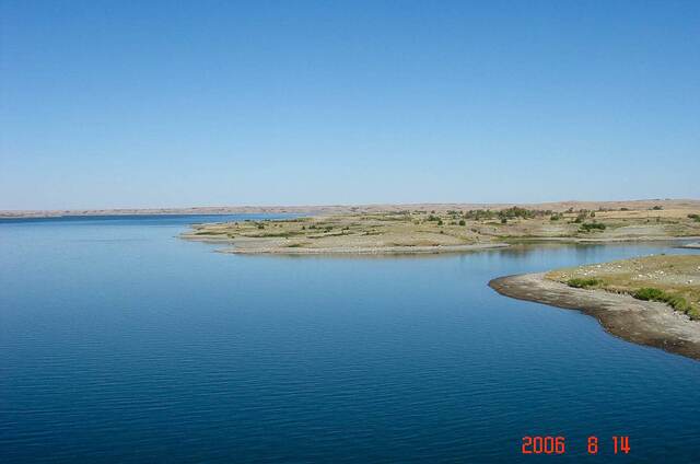 Another view of the blue lake and a distant tree-lined peninsula
