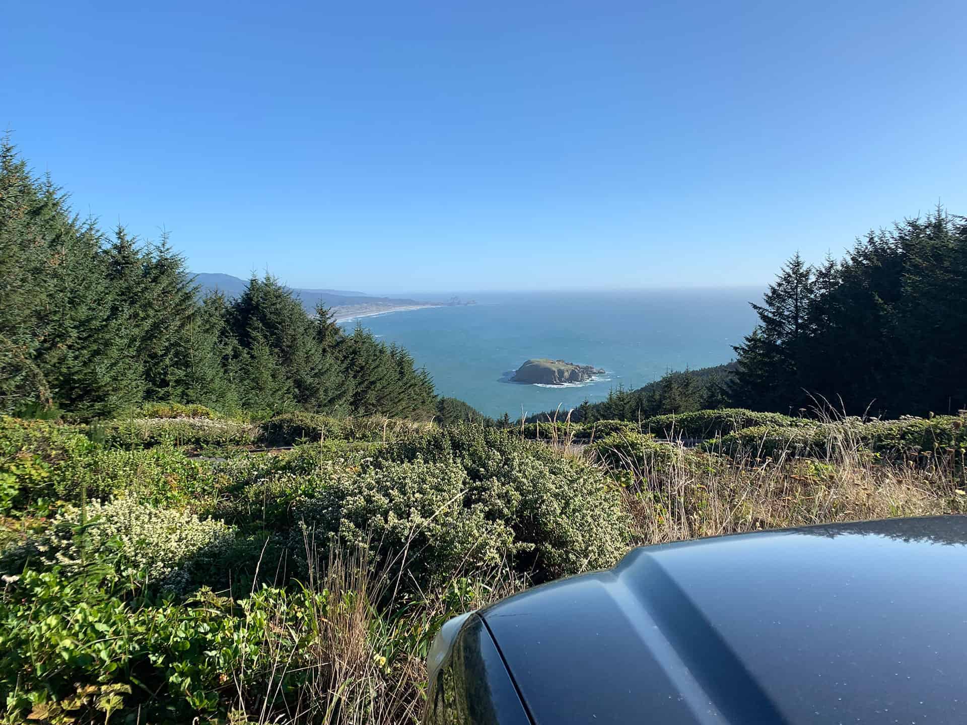 View of the Oregon coastline and a rocky sea stack from a car parked along Cape Sebastian