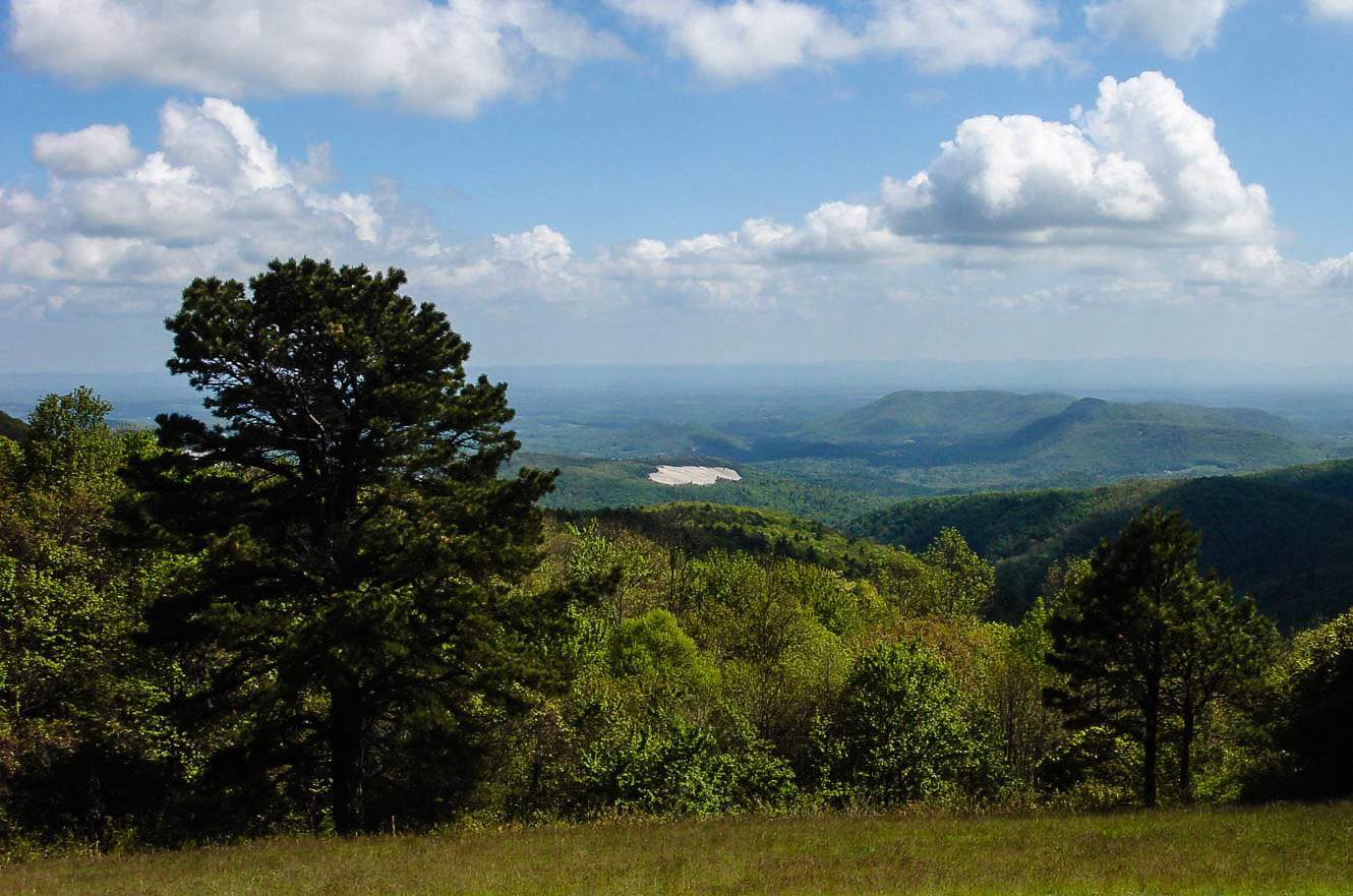 The Devils Garden Overlook sign on the Blue Ridge Parkway, with layered green mountains stretching into the distance