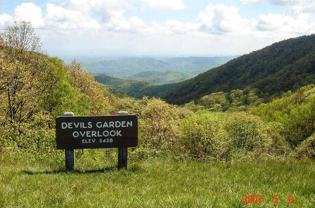 The Yadkin Valley Overlook sign on the Blue Ridge Parkway, looking out over hazy forested ridgelines