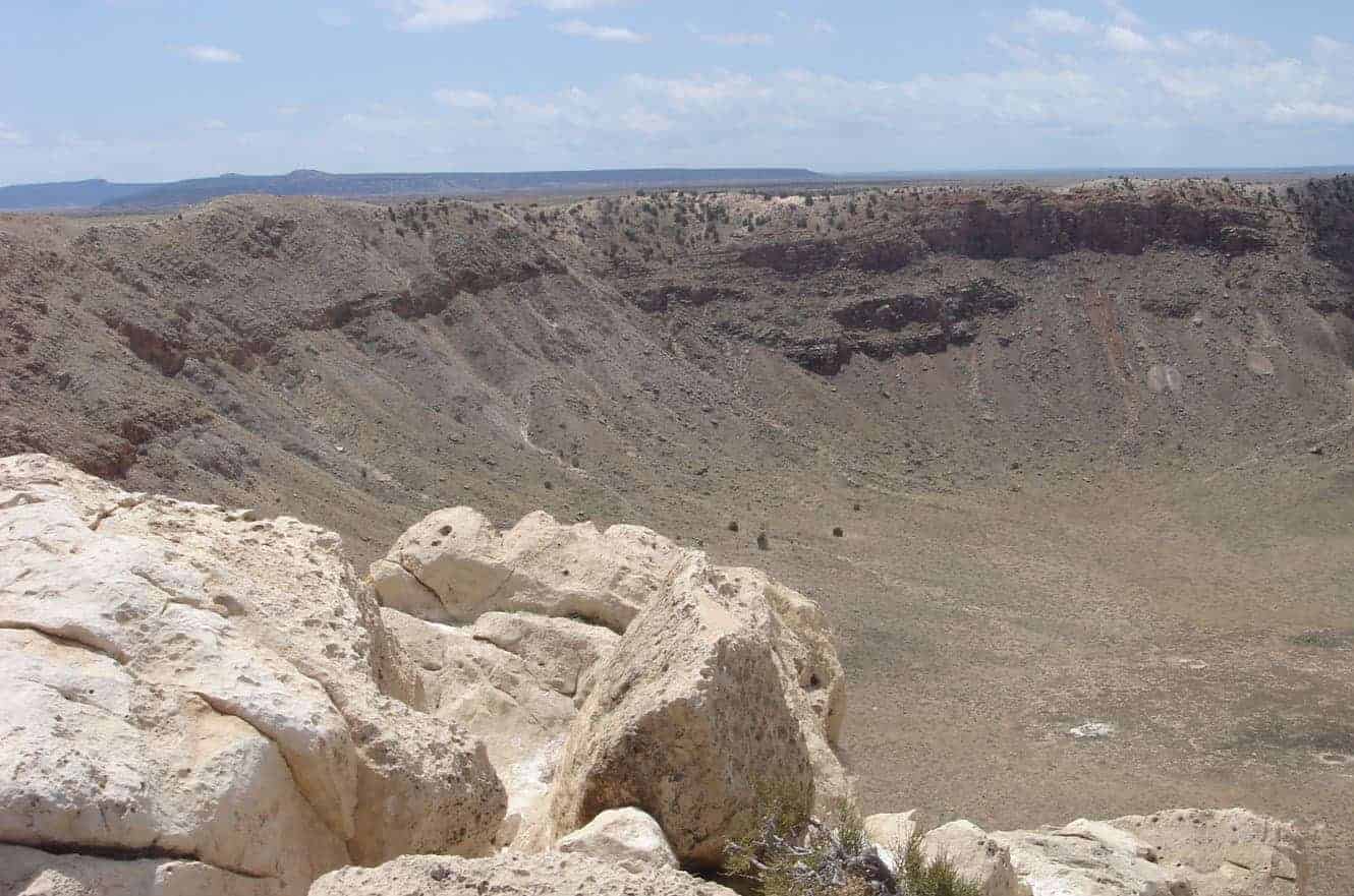 Looking down into the wide, bowl-shaped Meteor Crater from its rocky rim