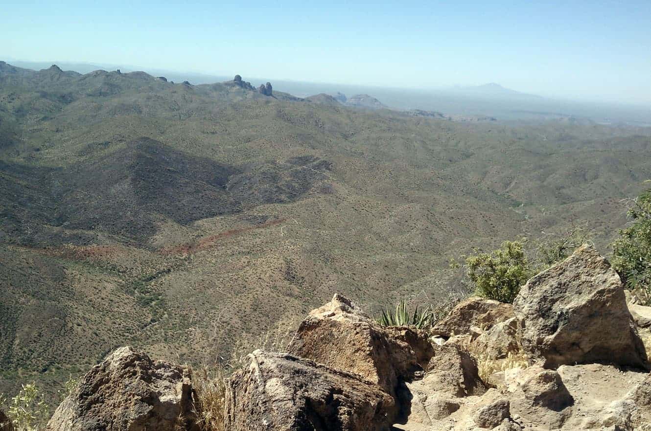 A panoramic view from the top of Picketpost Mountain across rugged desert peaks fading into haze