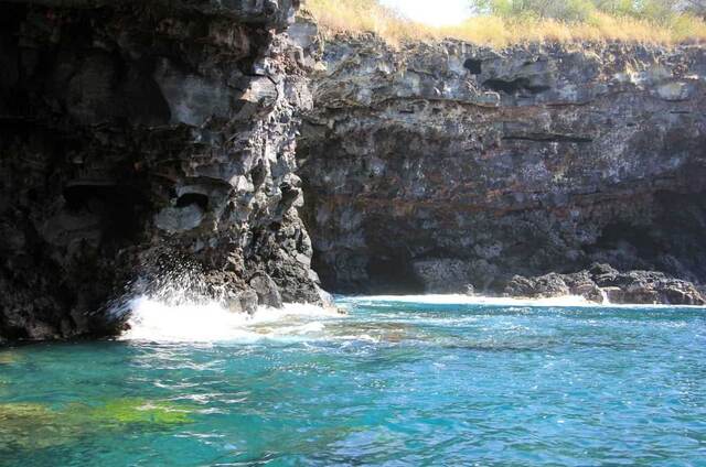 Waves crashing at the entrance of a lava sea cave