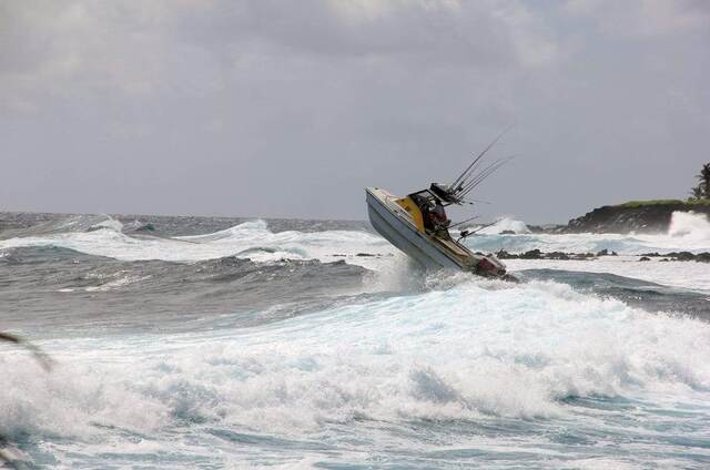 The fishing boat getting airborne off a wave near the rocky point